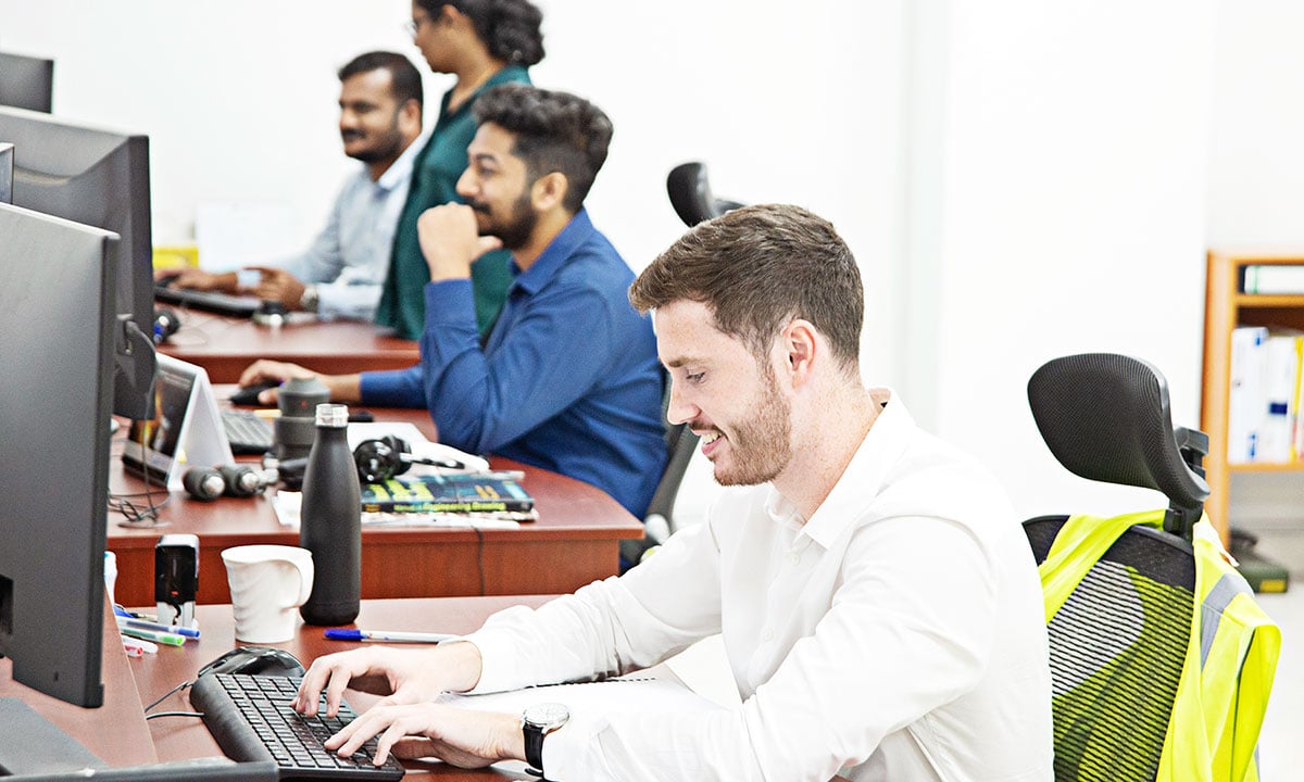 Staff working at a desk in the Abu Dhabi Office