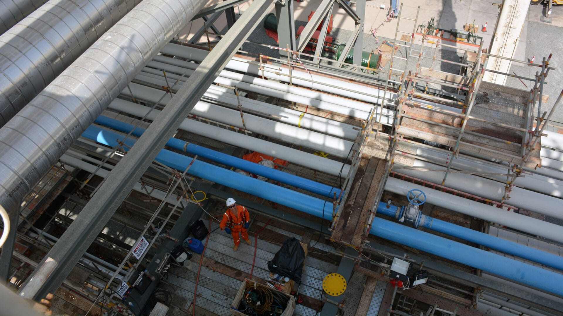 Looking down at a team member working on pipeline
