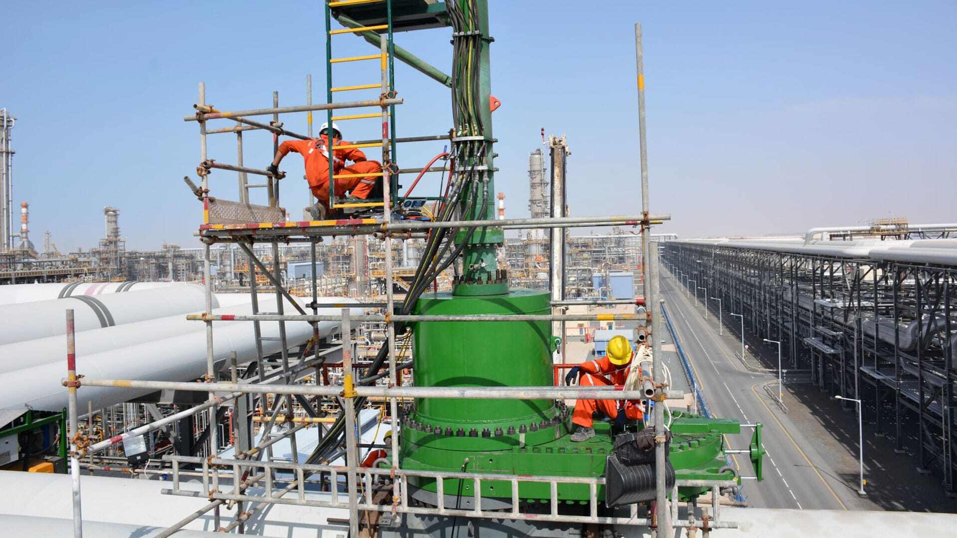 Team members working up high on pipeline in the middle east