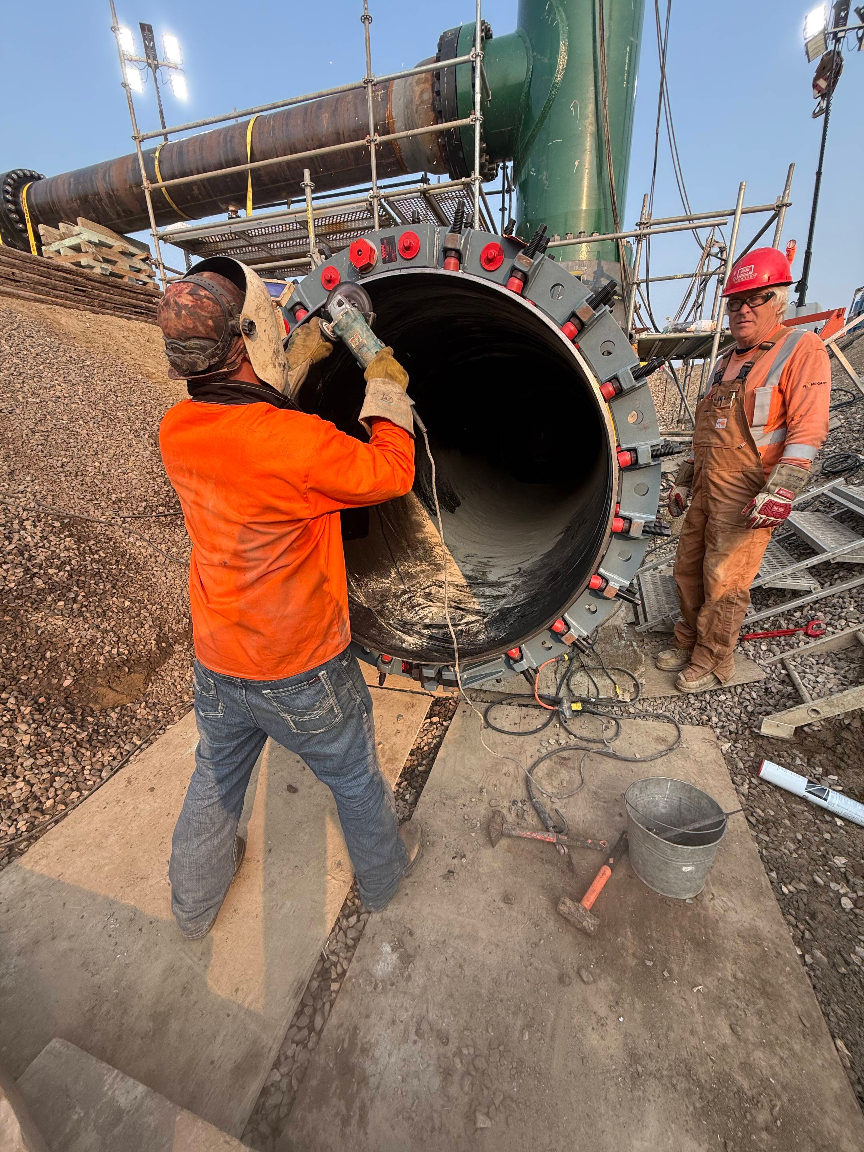 Welder prepares the bevel on the existing 48in pipe in preparation for welding the new pipe
